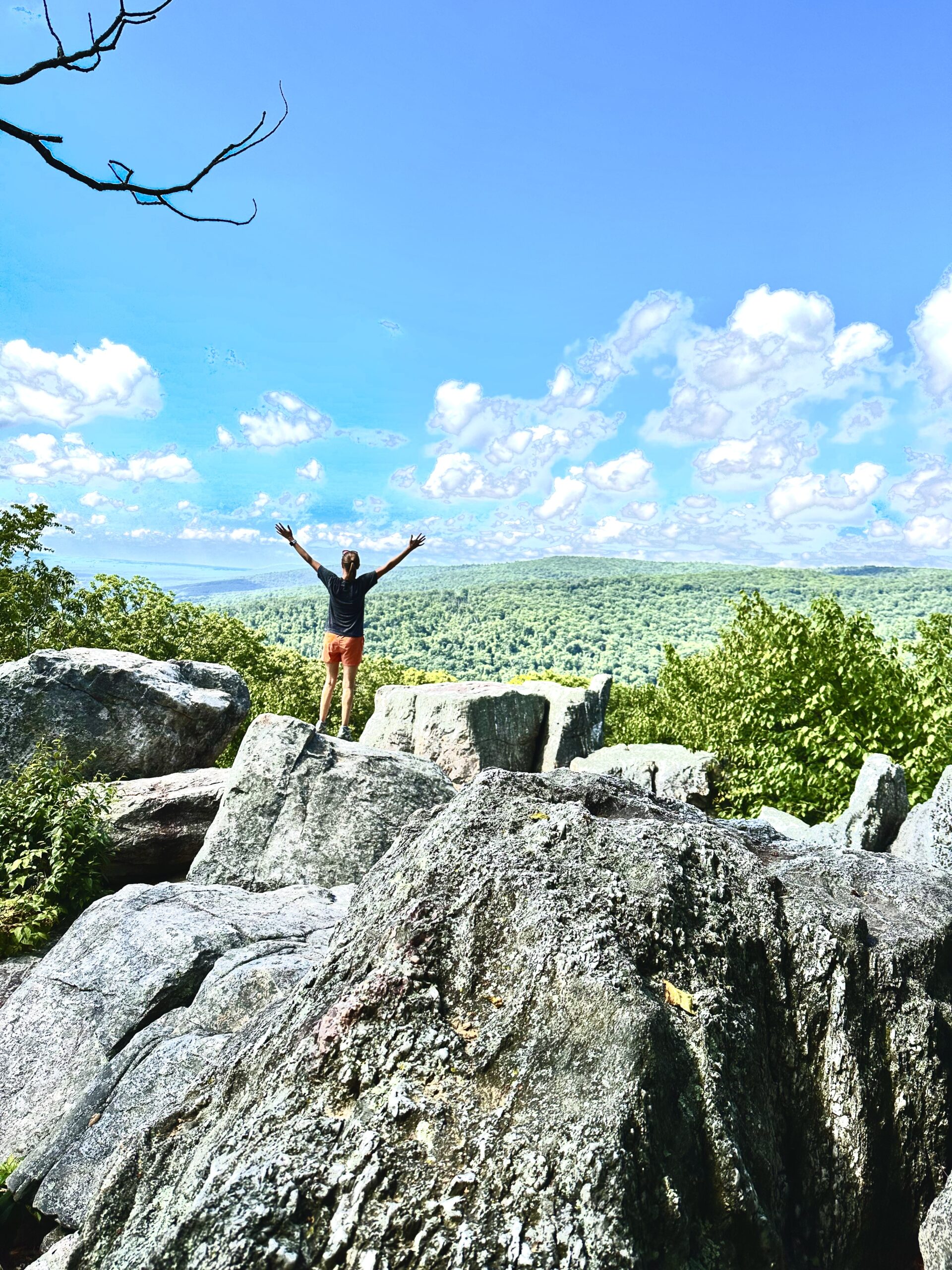 Silhouette of female standing on rocks at mountain overlook