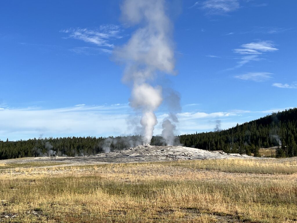Old Faithful Geyser with steam at Yellowstone