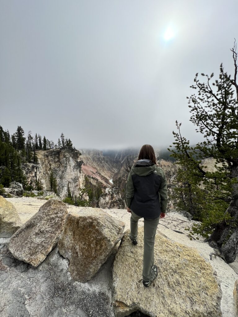 Female with foot up on rock overlooking Grand Canyon of Yellowstone